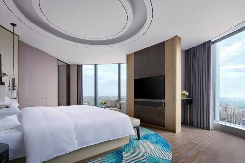 a bedroom with a large bed and a large window at Yancheng Marriott Hotel in Yancheng