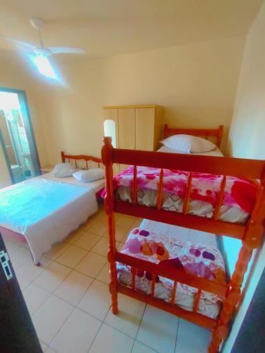 a bedroom with two bunk beds and a window at Pousada Nova in Tramandaí