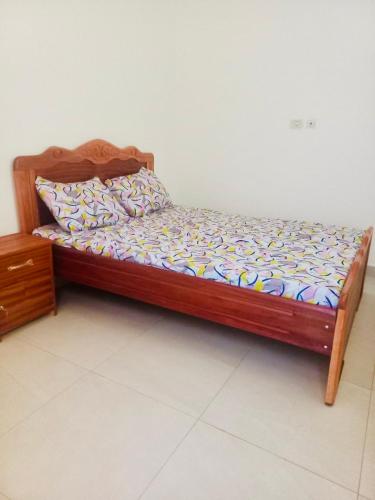 a bed in a room with a wooden frame at Villa Amina in Ouagadougou