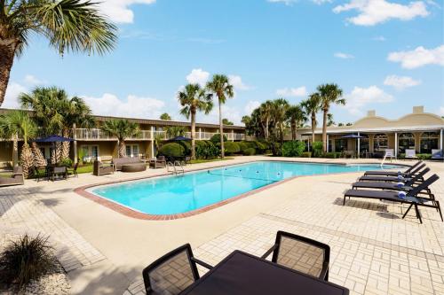 a swimming pool with lounge chairs and a resort at Four Points by Sheraton Destin - Fort Walton Beach in Fort Walton Beach