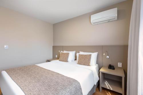 a hotel room with a bed and a air conditioner at Mercure Sao Paulo Moema in Sao Paulo