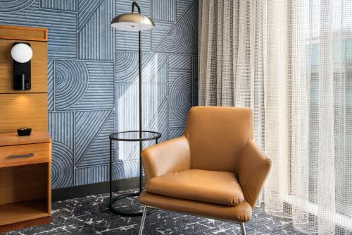 a brown chair in a room with a wall at Courtyard by Marriott Philadelphia South at The Navy Yard in Philadelphia