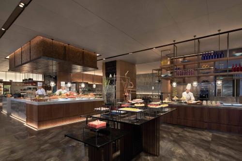 a restaurant with people preparing food in a kitchen at Yancheng Marriott Hotel in Yancheng