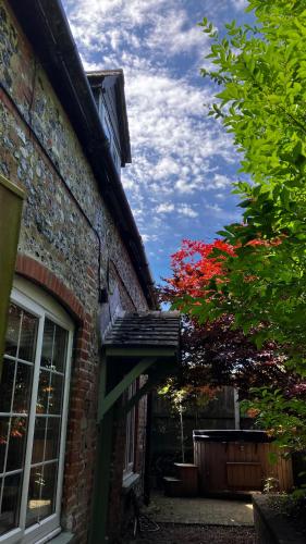 a brick building with a window and a red tree at Historic, traditional & Spacious Wiltshire Cottage in Shrewton