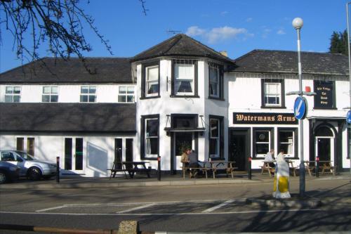 a white building on the corner of a street at OYO The Watermans Arms Hersham in Hersham