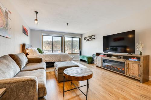 a living room with a couch and a flat screen tv at Walk to Dtwn Winter Park Studio with Hot Tub Access in Winter Park