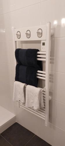 a white towel rack in a bathroom with towels at Escapade en Bretagne in Penmarcʼh