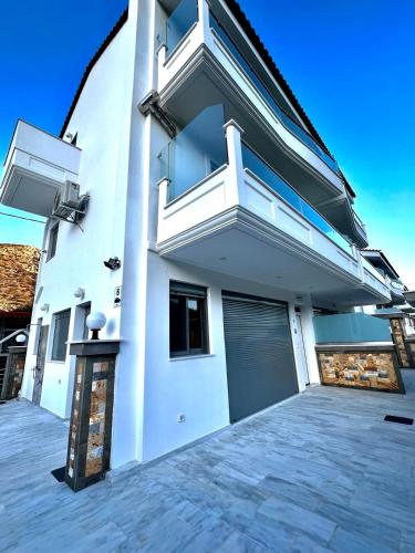 a white house with a door and a garage at ALTAVILLAS maisonettes in Kakí Vígla