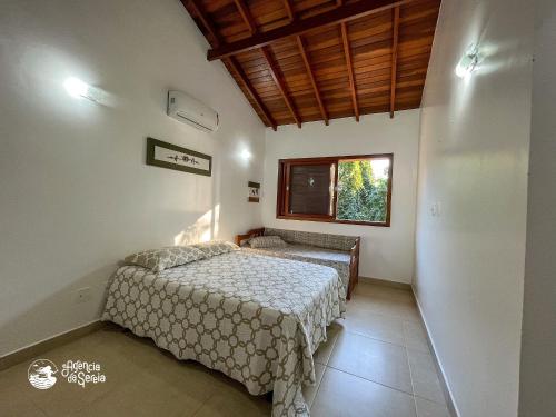 a bedroom with two beds and a window at Casa espaçosa Ilhabela perto da praia das Conchas in Ilhabela