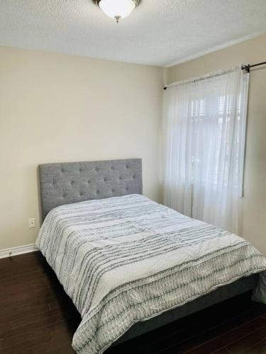 a bedroom with a bed and a window at Luxury 3 bedroom house in Mississauga