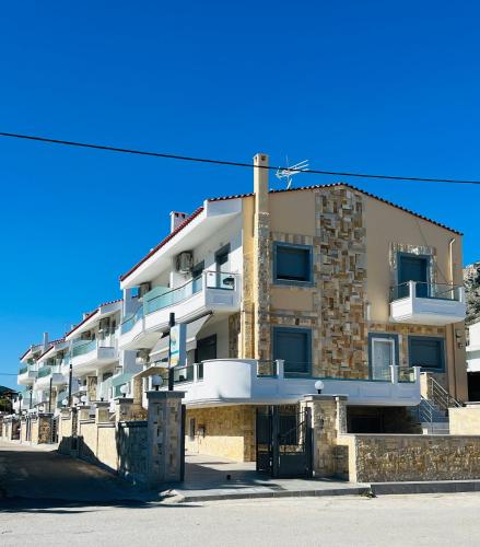 a large apartment building in front of a blue sky at ALTAVILLAS maisonettes in Kakí Vígla