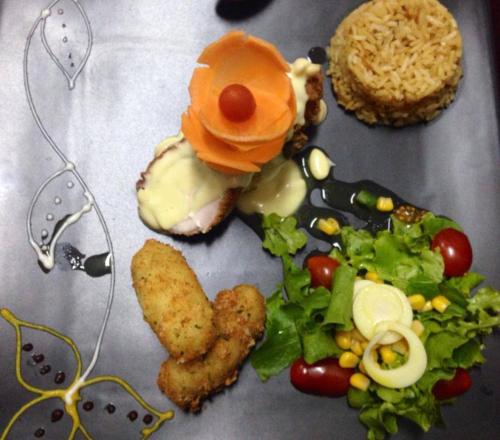 a plate of food with a sandwich and a salad at Roka Plaza Hotel Boutique in Ambato