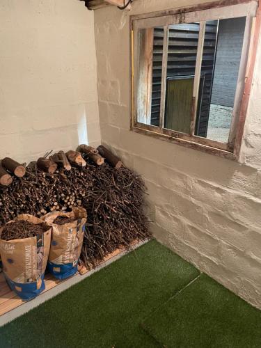 a wall with three buckets of wood next to a window at Les Charmes de Villers in Huchenneville