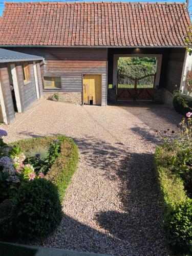 a driveway leading to a garage with a gate at Les Charmes de Villers in Huchenneville