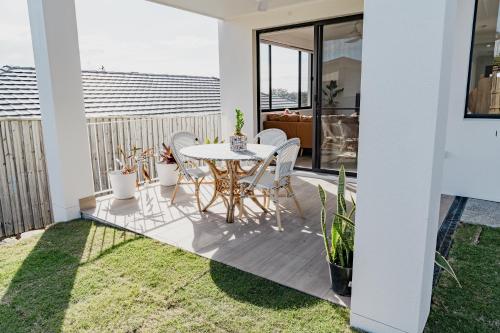 TerranoraEntire Unit with Own Entrance near Gold coast Airport for family holidays 04 Beds 2 rooms的露台上有一张桌子和几把椅子
