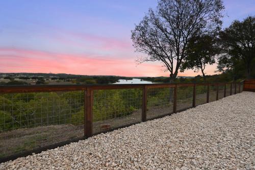 a wooden fence with a view of a river at Guadalupe Bluff Mediterranean in Kerrville