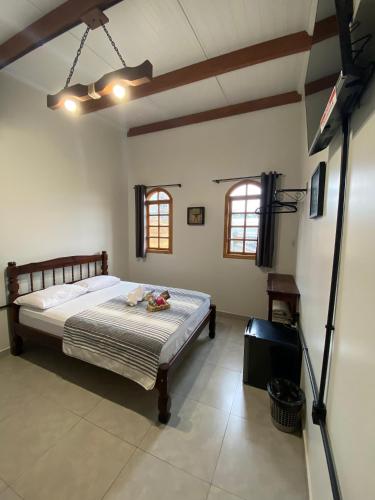 a bedroom with a bed and a tv in a room at Pousada Vila do Cowboy in Penha