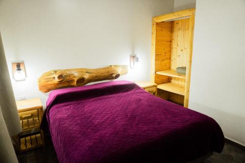 a bedroom with a bed and a log on the wall at Sueño de Pehuenia in Villa Pehuenia