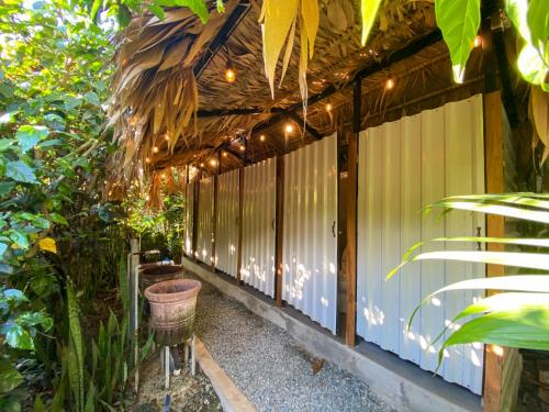 a patio with a pergola with a basket and lights at El Clan Hostel in Puerto Viejo