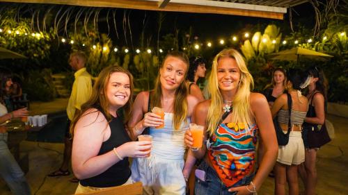 a group of girls holding drinks at a party at El Clan Hostel in Puerto Viejo