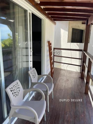 a balcony with chairs and a view of the ocean at Casas de Juan in Morro de São Paulo