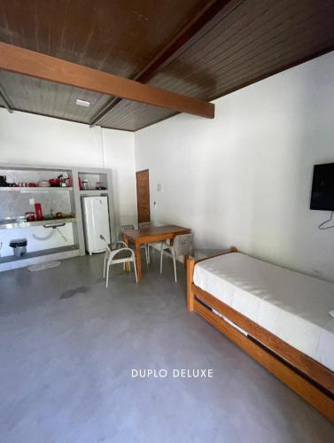 a bedroom with a bed and a desk and a table at Casas de Juan in Morro de São Paulo