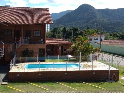 ein Swimmingpool vor einem Haus in der Unterkunft Kitnet na Martim de Sá - Caraguatatuba in Caraguatatuba