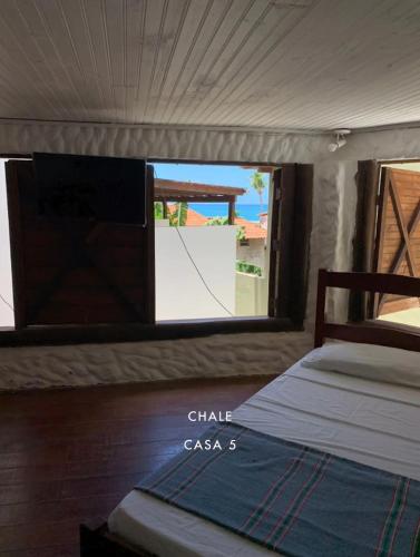 a bedroom with a bed and a view of the ocean at Casas de Juan in Morro de São Paulo