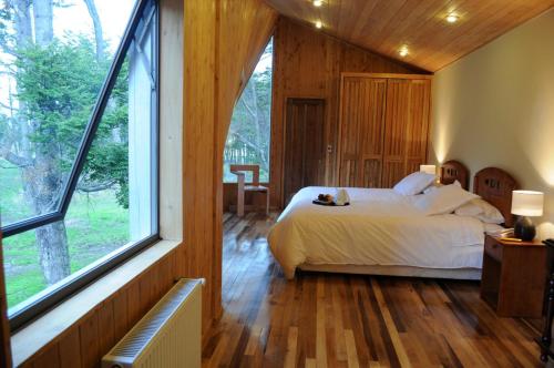 a bedroom with a bed and a large window at Casa Bahía Patagonia in Bahía Murta