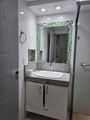 a bathroom with a sink and a mirror at CIG Hostel in Goiânia