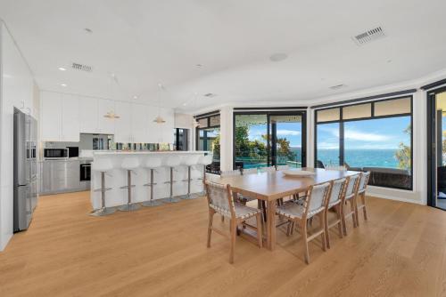 a kitchen and dining room with a table and chairs at Bellevue at Hyams, Hyams Beach in Hyams Beach