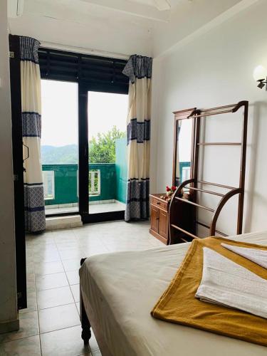 a bedroom with a bed and a large window at Green View Holiday Resort in Elkaduwa