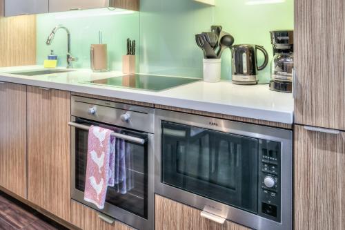 a kitchen with a sink and a microwave at Rivetstays - The Atmos I in Toronto