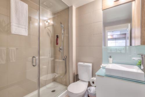 a bathroom with a shower and a toilet and a sink at Rivetstays - The Atmos I in Toronto
