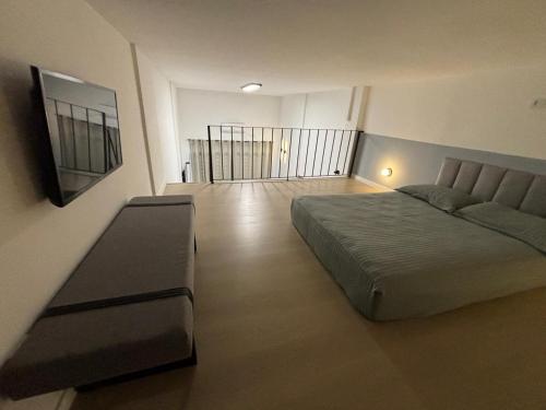 ein Schlafzimmer mit einem Bett und einer Couch darin in der Unterkunft LOFT MUNDI - Conforto no Centro com Ar Condicionado in Águas de Lindóia