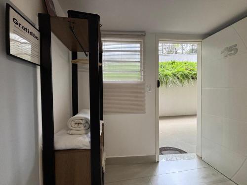 Zimmer mit einer Tür, die zu einem Schlafzimmer führt in der Unterkunft LOFT MUNDI - Conforto no Centro com Ar Condicionado in Águas de Lindóia