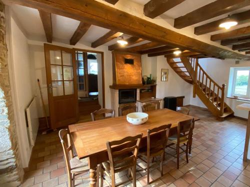 une cuisine et une salle à manger avec une table et des chaises en bois dans l'établissement Gîte écologique familial en campagne, idéal pour sports et nature - FR-1-410-452, à Moulins-le-Carbonnel
