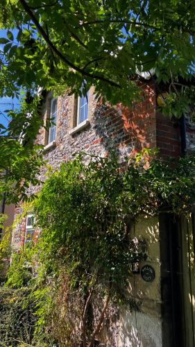 a brick building with a tree in front of it at Historic, traditional & Spacious Wiltshire Cottage in Shrewton