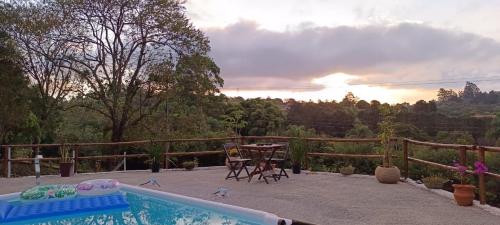 a backyard with a pool and a table and chairs at Espaço Azul in Ibiúna