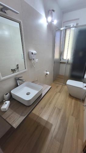 a bathroom with a sink and a toilet and a mirror at Villa Andres in Sassari