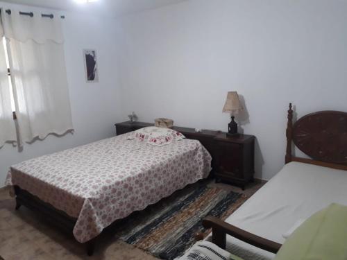 a bedroom with two beds and a table and a chair at Espaço Azul in Ibiúna