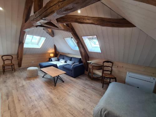 an attic room with a blue couch and a table at Gîte Grand Capacité avec Parking et Animaux Admis - FR-1-590-370 in Briare