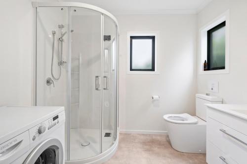 un bagno bianco con doccia e WC di Birch Cottage - Greytown Holiday Home a Greytown