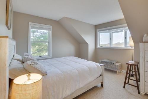 a bedroom with a large bed and two windows at 6 Mi to Sunday River Condo Near Bethel Village! in Bethel