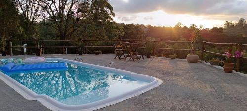 a hot tub sitting on a patio with a table at Espaço Azul in Ibiúna