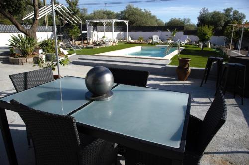a black table with chairs and a swimming pool at Villa Andres in Sassari