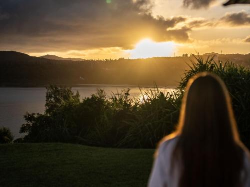 a woman looking at the sunset over a lake at Oriental Hills Okinawa in Onna