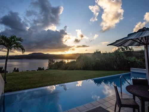 a swimming pool with a view of a lake at Oriental Hills Okinawa in Onna