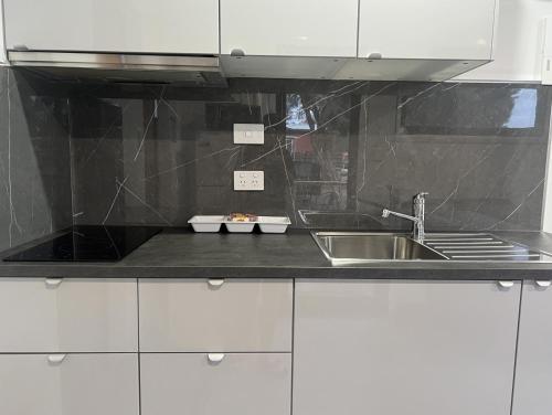 a kitchen with white cabinets and a sink at Whyalla Caravan And Tourist Park in Whyalla