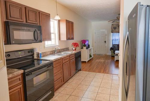 a kitchen with wooden cabinets and a stainless steel refrigerator at Lovely 2-level 2-bedroom cottage, 1 block to beach in Myrtle Beach